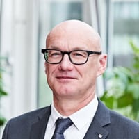 Ein Foto des Unternehmensführers Ulrich Wessels. Er ist ein Mann mit blauen Augen. Er trägt eine Brille.